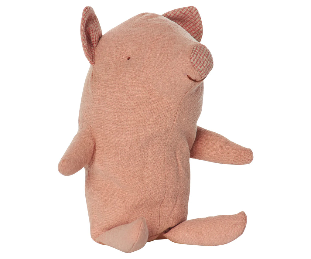 The Maileg Truffles the Pig, Baby is a soft, plush toy featuring light pink fabric and checkered patterns inside its ears. Made from recycled polyester, this adorable pig has a simple design with minimal facial features and a slightly curved body.