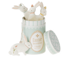 A pastel green cylindrical container labeled "Maileg Easter Bunny Ornaments, 5 pcs." has its lid off. Four sweet bunny ornaments with flower accents are inside, and one bunny ornament lies on its side beside the container.