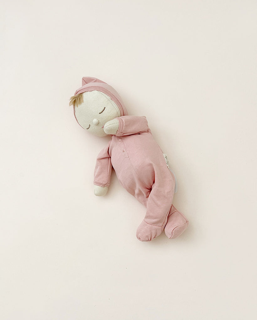 Sleeping doll in pink pajamas. 