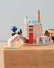 A Las Vegas wooden music box featuring iconic buildings and unique cultural landmarks, including bridges and towers, all set on a circular wooden base against a plain background.