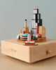 A Chicago Wooden Music Box model of Chicago's famous landmarks, artistically arranged on a layered platform with a labeled front, set against a soft beige background.