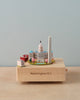 A Washington D.C. Wooden Music Box features a miniature model of Washington D.C., including notable landmarks like the Capitol building and the Washington Monument. The piece, set against a light blue background, plays a melodic tune and has "Washington D.C." inscribed on its base, celebrating America's unique culture and landmarks.