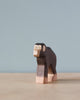 A high-quality Handmade Holzwald Chimpanzee sculpture with a detailed and expressive face, painted in black and brown tones, against a soft blue background.