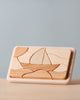 A Handmade Wooden Puzzle featuring a simplistic design of a sailboat on water with a sun or moon in the sky. Handmade in Russia, the puzzle pieces are crafted from different shades of natural wood, including cherry wood, and treated with linseed oil to enhance their beauty. The pieces fit into a rectangular frame, creating an image when assembled.