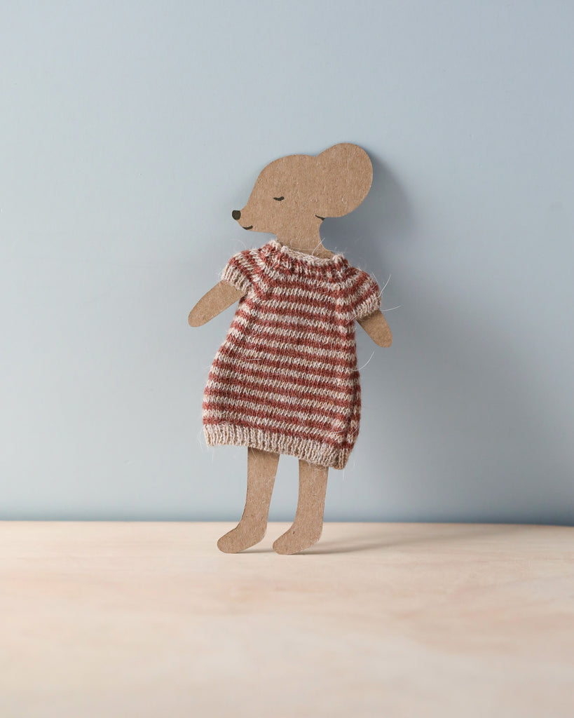 A cardboard cutout of a mouse stands upright against a light blue background. The mouse is dressed in a charming Maileg Knitted Dress For Mum Mouse, accentuating its minimalistic and delightful design.