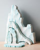 A Handmade Wooden Penguin Set, resembling an icy mountainous landscape, sits on a light wooden surface against a plain, light gray background. The cool blue and white tones evoke a frosty appearance similar to glacial formations, all crafted with non-toxic paints.