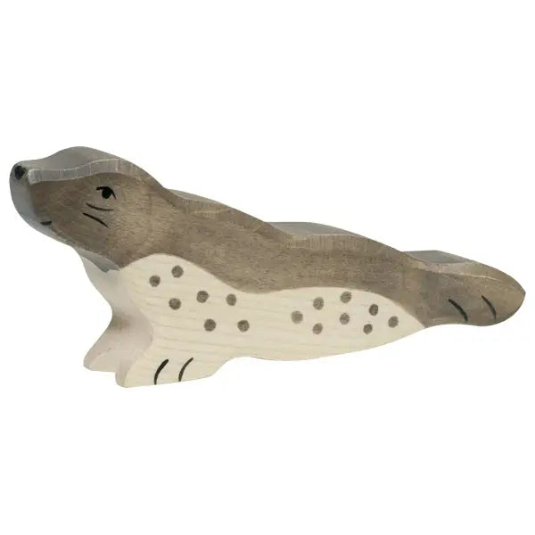 A wooden, hand-painted Holztiger Seal, Head Forward with a grey and white body, black spots on its side, and black whisker and eye details. Handcrafted from maple and beech wood, the toy is posed with its head slightly raised in a resting position.