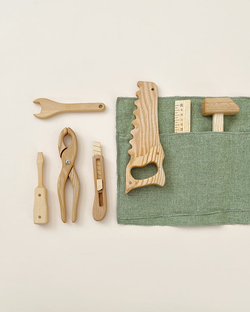 Seven wooden tool toys in a rollup canvas. 