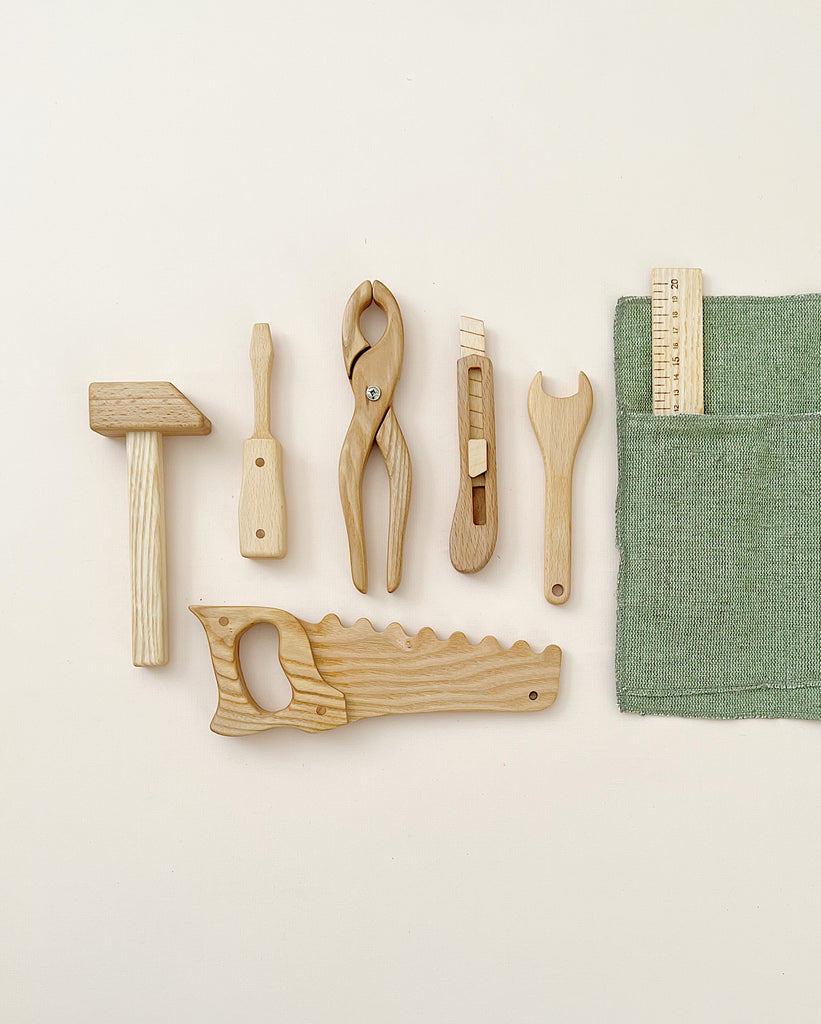 Seven wooden tool toys in a rollup canvas. 