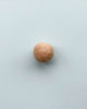 a light brown felt ball on a light blue background.