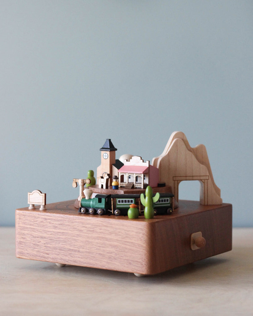 Wooden music box with the theme of a Western town and a train going around