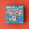 A box containing the "Londji - Dino Explorer Puzzle (350 pcs)" is shown against a red background. The blue box features illustrations of various dinosaurs and a kaleidoscope. This educational toy puzzle, measuring 80x32 cm with 350 pieces, proudly displays the Londji brand name at the bottom.