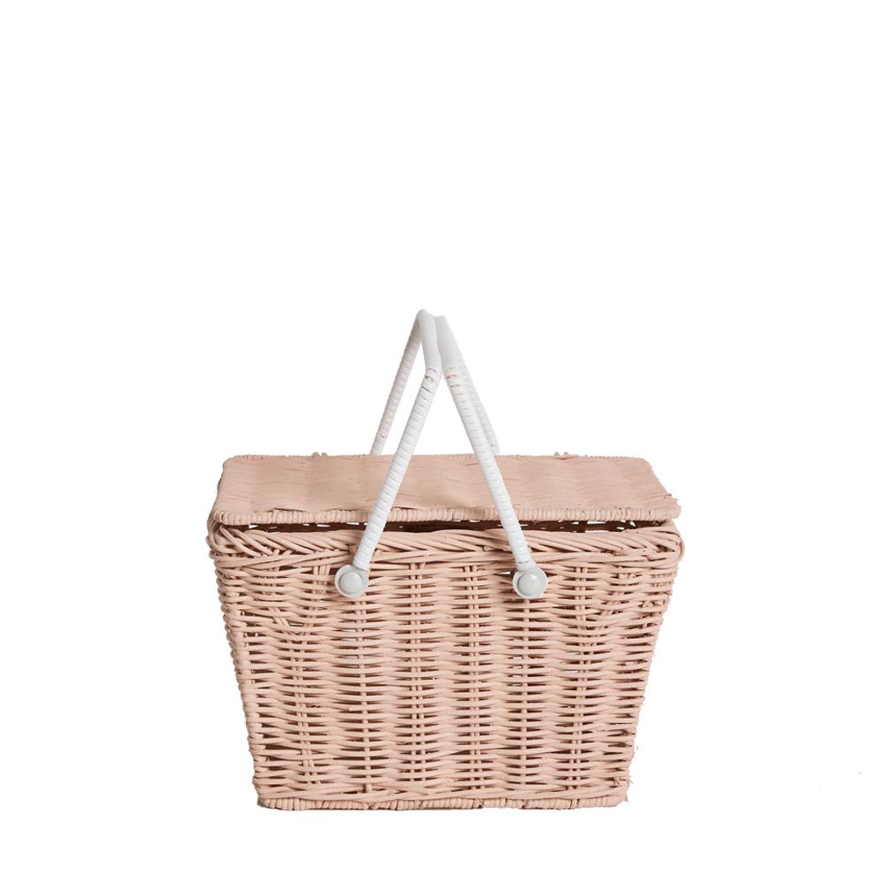 A hand-woven Olli  Ella | Piki Basket picnic basket with a closed lid and white carrying handles, isolated on a white background.