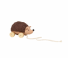 A soft, plush hedgehog toy named "Hedgehog Pull Toy," with a textured brown back and beige front, is mounted on four wooden wheels. A white pull string is attached to the front, allowing the toy to be dragged along. Made from organic cotton, it fits perfectly in any enchanted forest adventure.