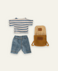 A set of children's clothing and accessories laid out on a light background, including a blue and white striped T-shirt, blue denim shorts, and an open yellow backpack with a checkered interior—perfect for Maileg Extra Clothing: Clothes & Bag for Big Brother.