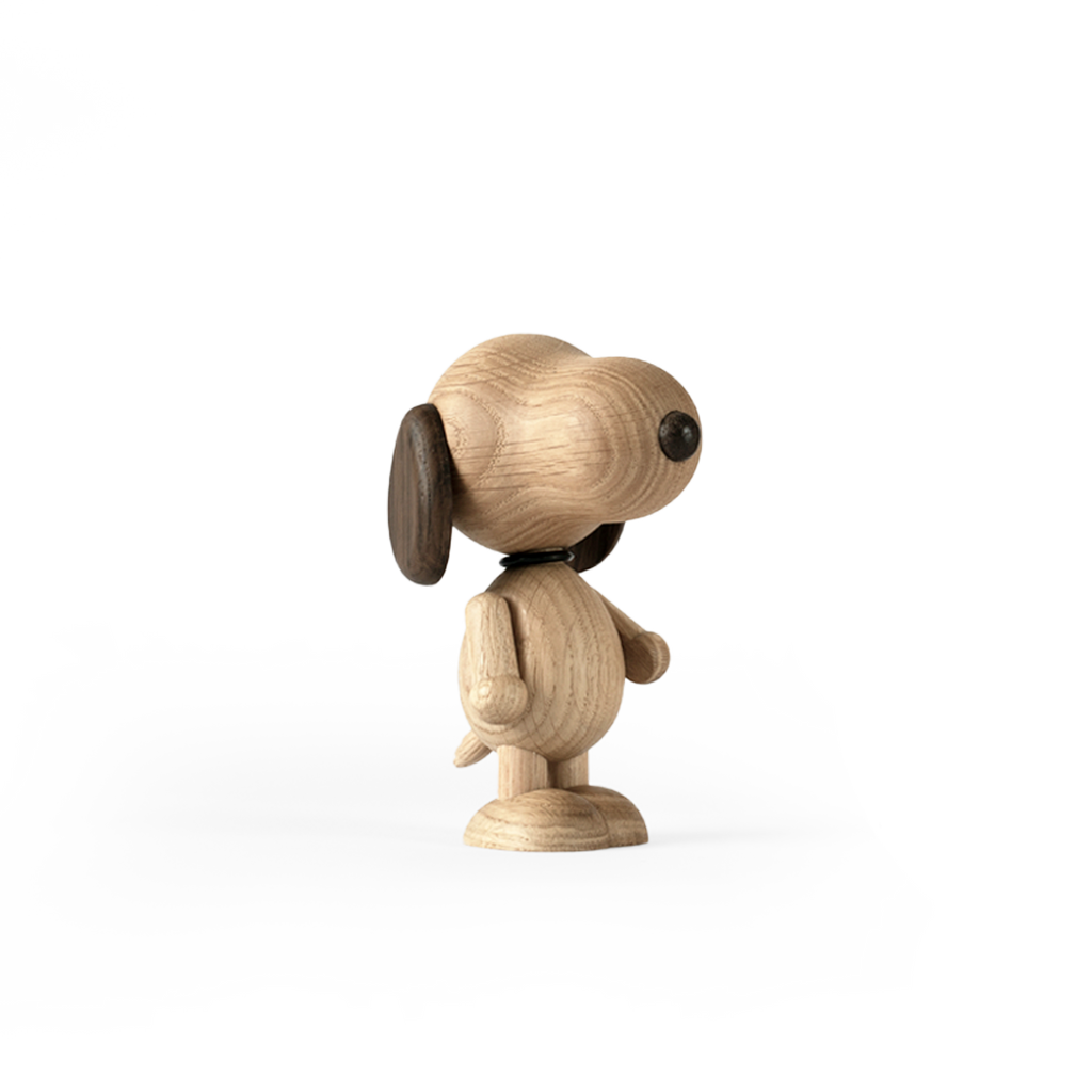 A Boyhood Snoopy, Small figurine with large, round eyes and prominent ears, standing upright and facing left, set against a soft gray and white background.