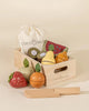 Natural color wooden crate with wooden brown kiwi, wooden red strawberry, wooden red and green slice of watermelon, wooden yellow pear, wooden orange mandarin. Also includes a canvas beige bag with string to put wooden fruits in it and a wooden natural color pretend play knife. 