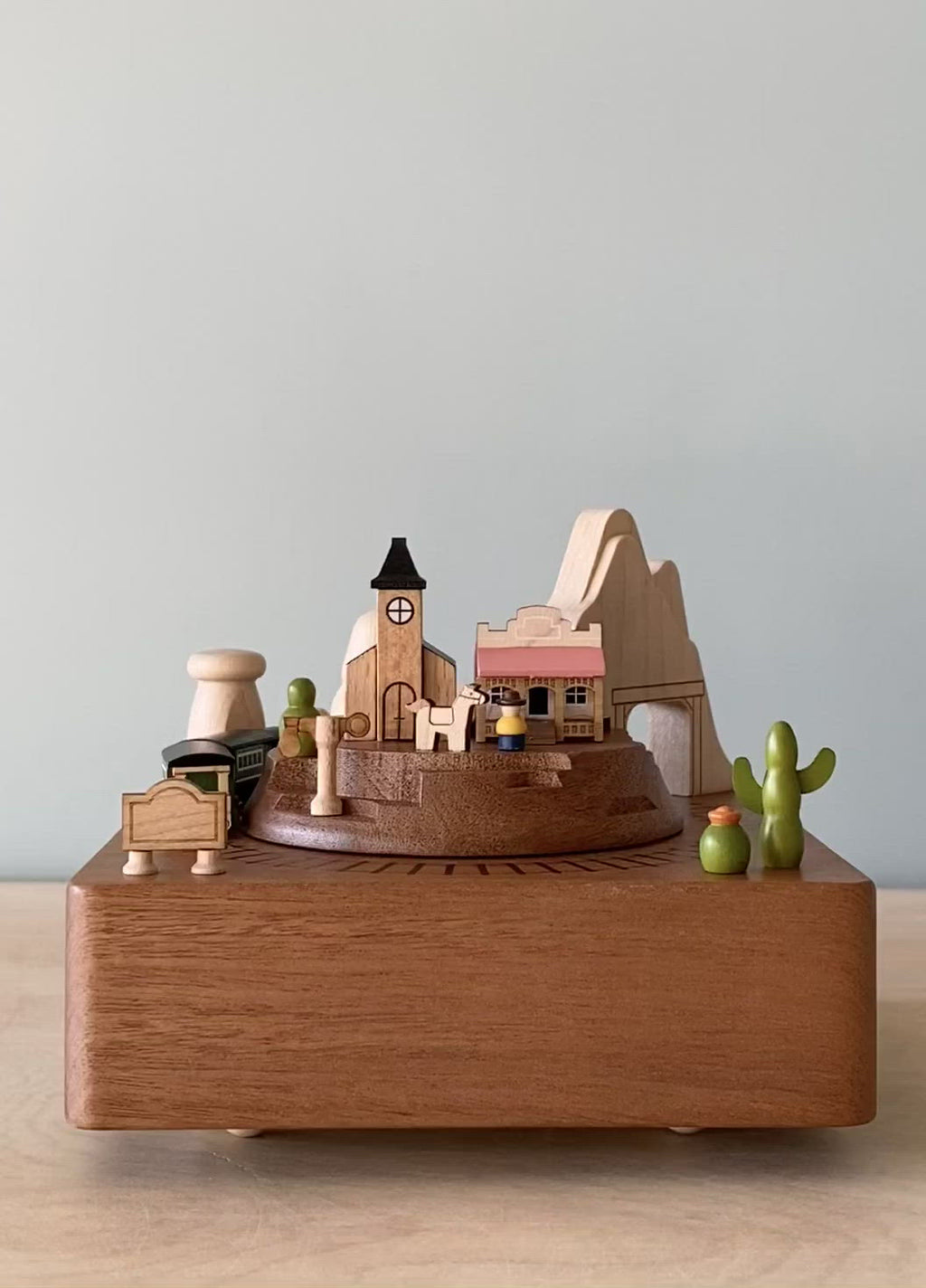 Wooden music box with the theme of a Western town and a train going around