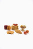 A Sabo Concept Handmade Wooden Bakery Set is displayed on a white background, featuring a delightful collection of children’s play food, including a stack of pancakes with strawberries, jars of jam and honey, a croissant, toast, peaches, and a bowl of fruits. All items are painted with non-toxic paint for safe play.