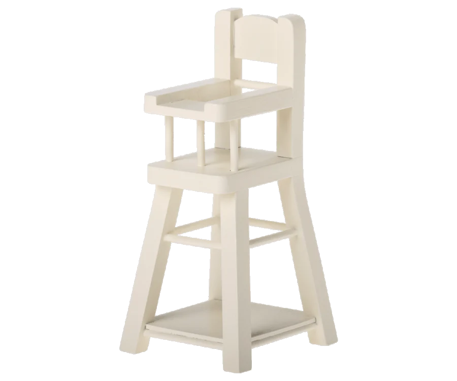 A tall, white wooden Maileg Micro High Chair designed for children. It features a solid seat with a backrest, armrests, and a footrest bar. Perfect for little ones or their micro-sized Maileg friends, the chair has four sturdy legs and a rectangular base for stability.