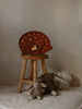 A cozy Handmade Bear Lamp in the shape of a sleeping bear sits atop a wooden stool, flanked by two plush teddy bears, against a muted backdrop.