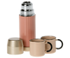 A Maileg | Miniature Thermos And Cups accompanied by two matching cups with black handles and magnetic hands, all set against a white background.