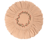 A round, beige Maileg Cushion, Small with a pleated edge and a center embroidered with a red and green floral wreath design, set against a black background.