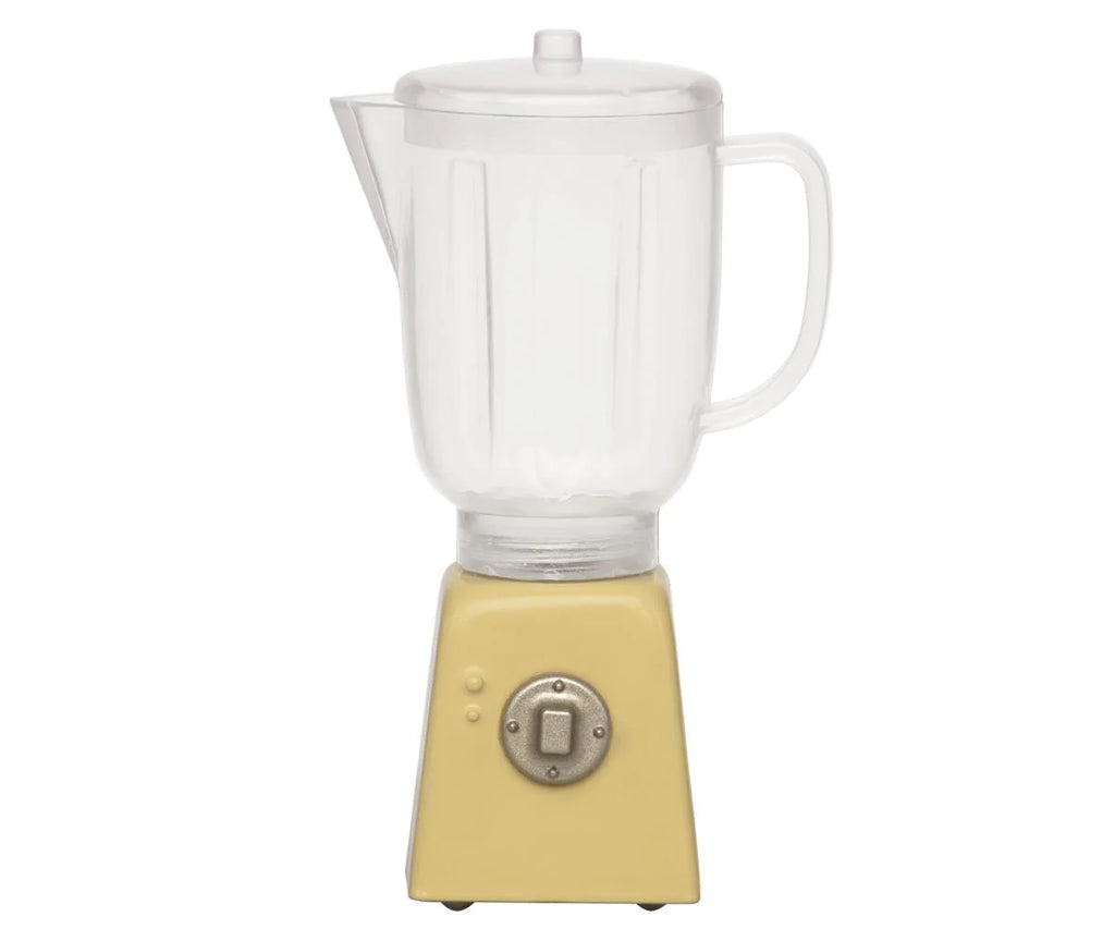 An image of a Maileg Miniature Blender featuring a transparent pitcher with a lid and handle. The base is a light yellow color with a single square button in the center, giving it a vintage appearance. Perfect for children's toy collections or pretend play, the blender is set against a white background.