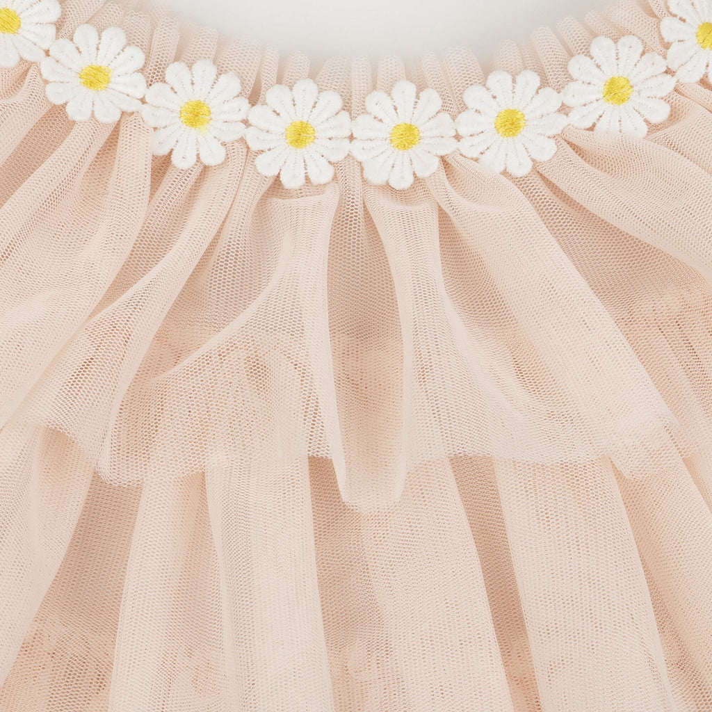 Close-up of a Meri Meri Peach Tulle Bunny Costume adorned with a row of white daisy appliques along the top edge, creating a delicate and feminine texture.