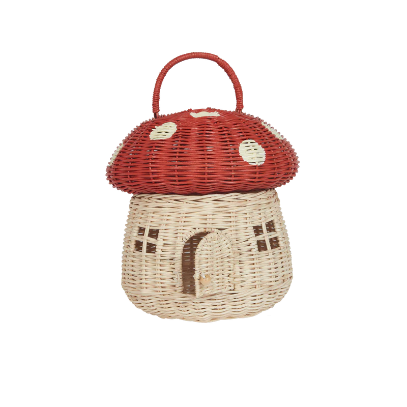 Olli Ella Red Mushroom Basket shaped like a mushroom house with a red cap, featuring white dots and window cut-outs against a striped black background.